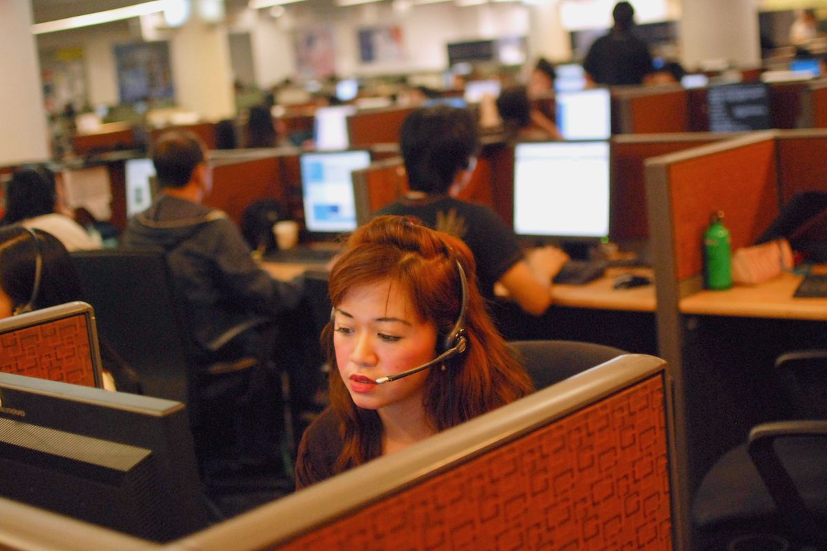 An Female customer support agent with red hair and a headset