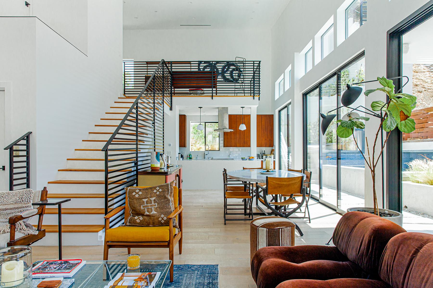 A 2 Story Air BnB Interior with a wooden staircase and black balustrades and glass window