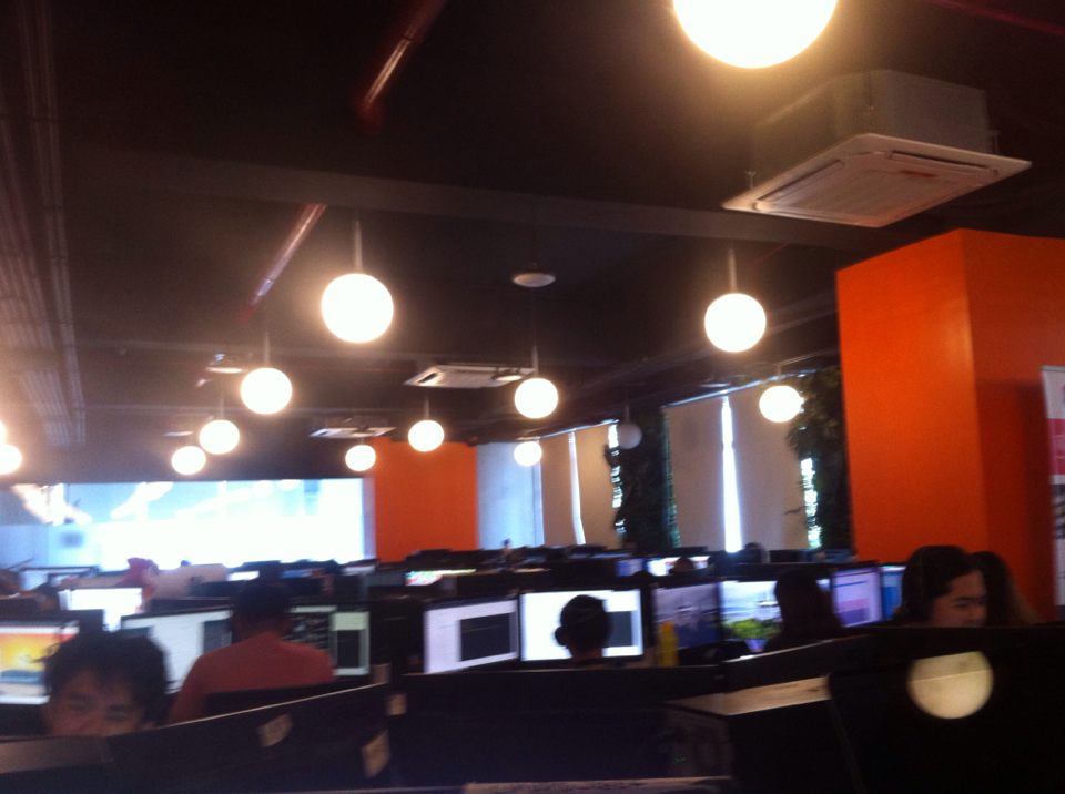 A BPO Call Center Office with various Outsourcing Personnel A BPO Office with Computer Monitors and Orange Walls
