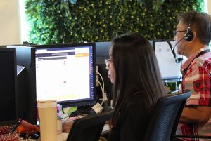 A Female Call Center Employee in Black and Man Taking Calls in red Checkered Shirt