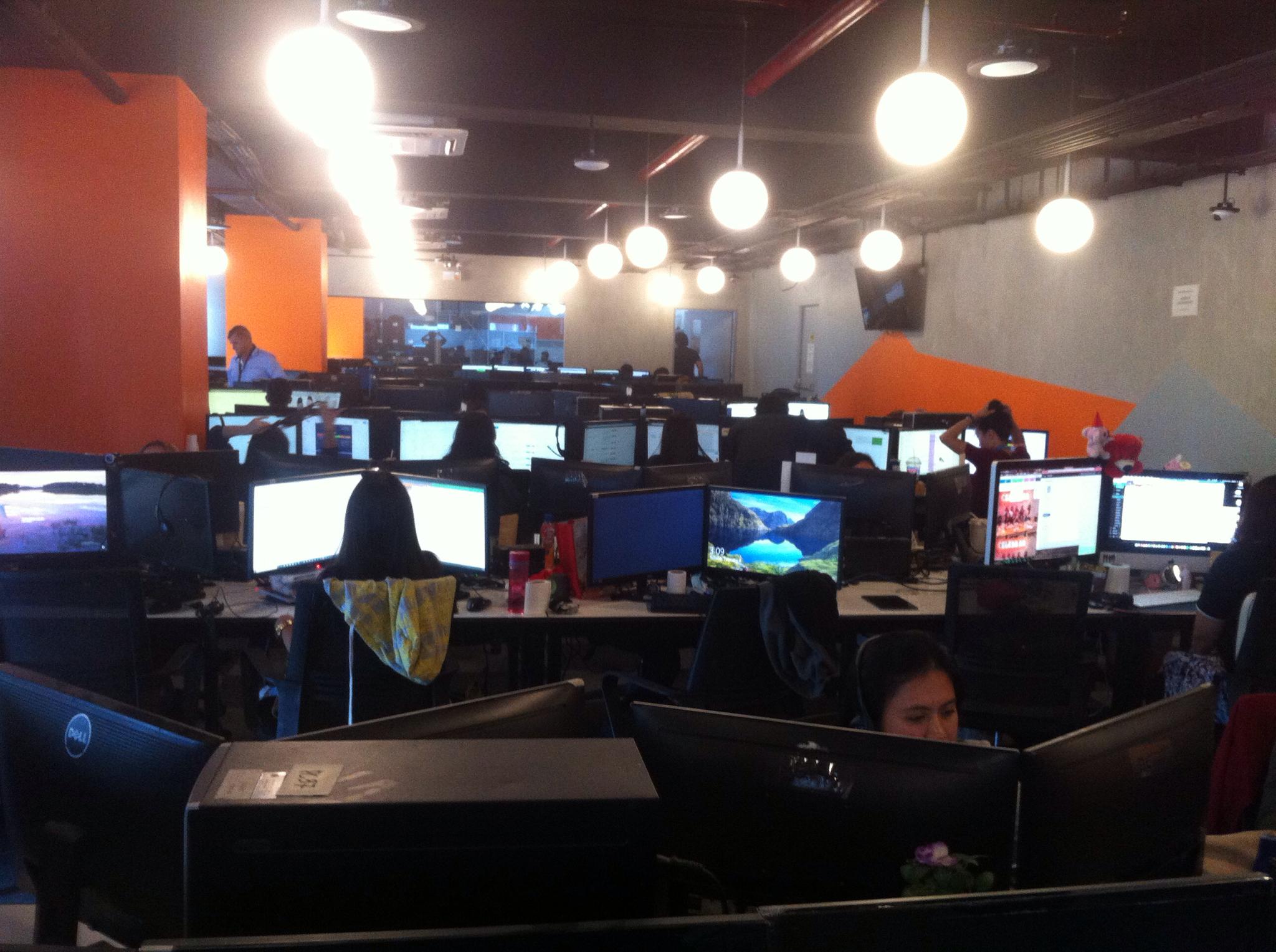 A Logistics outsourcing Office with Orange walls and Computer Monitors