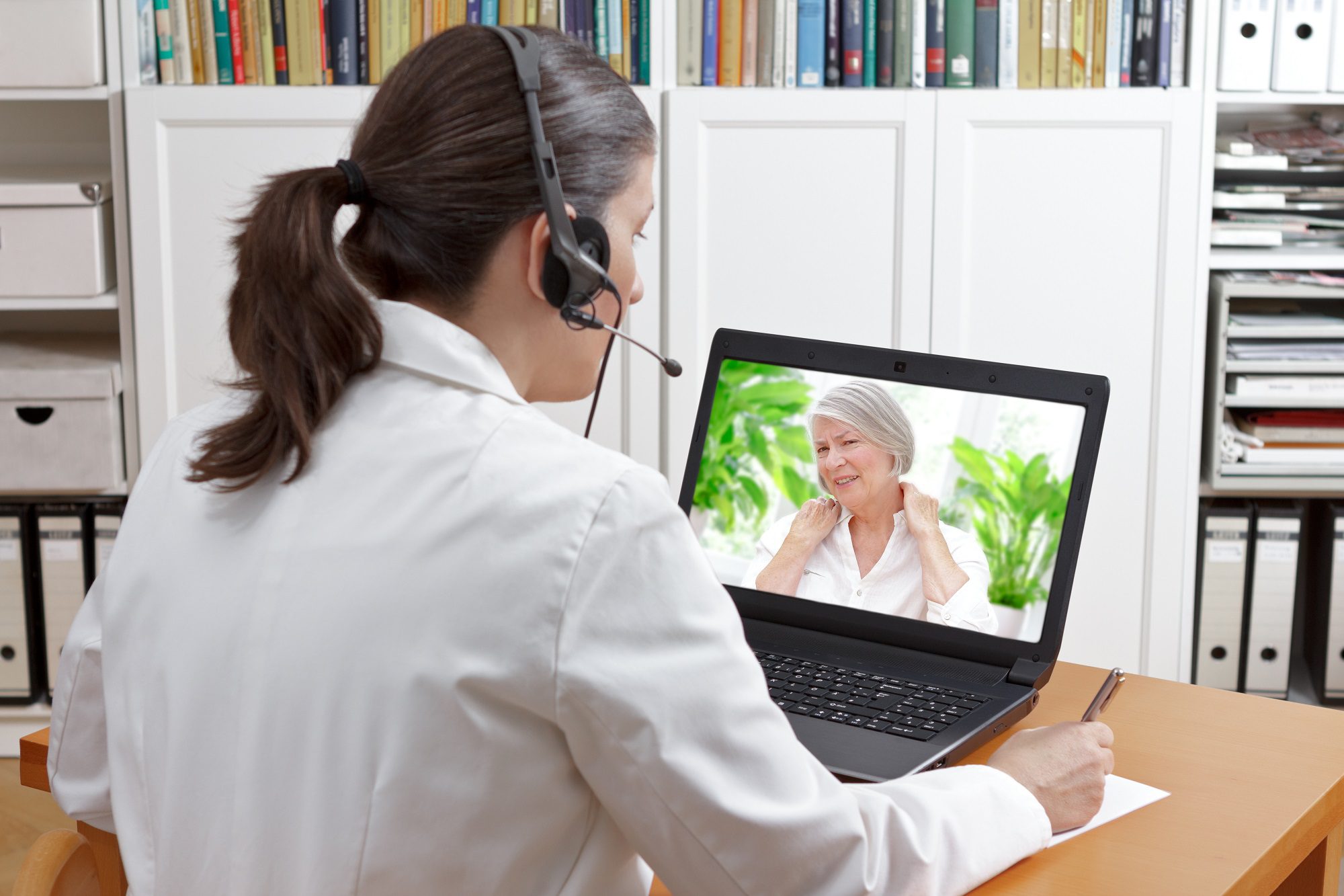a female telemedicine practitioner attending to an elderly lady over a laptop