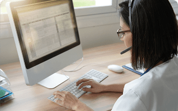 female outsourcing employee with headset working on computer