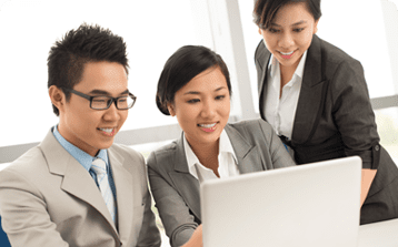 3 remote employees looking at a laptop