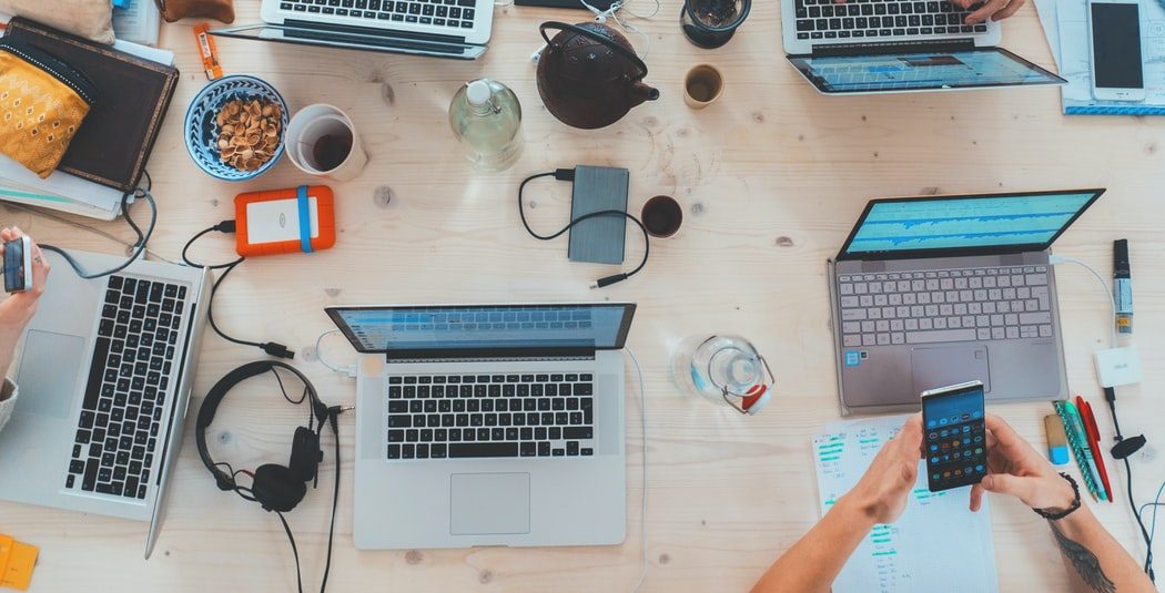 table full of laptops – people brainstorming their outsource digital marketing table full of laptops - people brainstorming their outsource digital marketing
